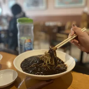 a bowl of noodles with chopsticks