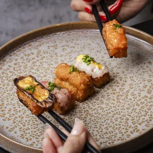 a plate of sushi with chopsticks