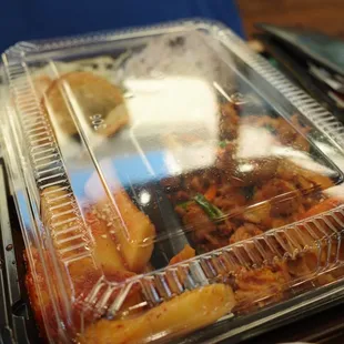 a plastic container of food and a bowl of soup