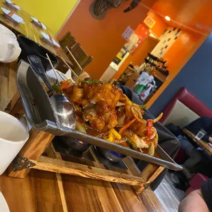 Fish skewers with vegetables in sauce on hot plate