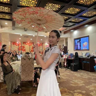 a woman in a white dress holding an umbrella