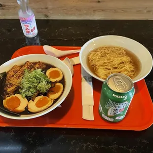 a bowl of ramen, a can of soda, and a bowl of noodles