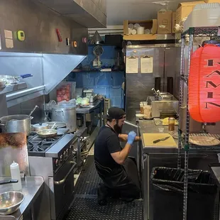 This is the Master Chef and owner making his magic perfecting each delicious bowl of goodness that comes out of his kitchen.