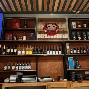 a wooden bar with shelves of wine bottles