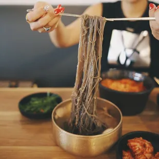a woman eating noodles