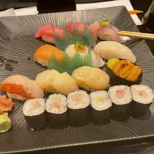 Assorted special sushi of the night with a few missing pieces of nigiri and a traditional yellowtail roll