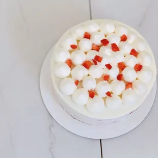 a white cake with strawberries and marshmallows