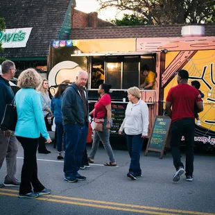 a group of people standing in front of a food truck