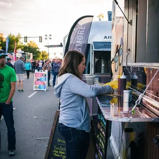 a woman ordering food from a food truck