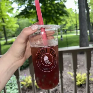 a hand holding a cup of boba tea