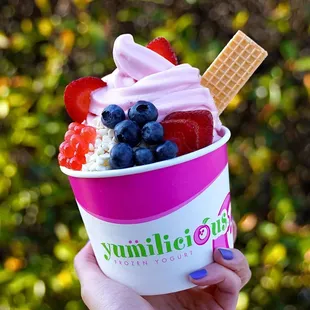 a person holding a cup of yogurt