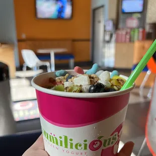a person holding a cup of yogurt