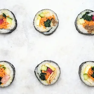 Variety of different kimbap pieces by yumkimbap; bite-sized and delicious
