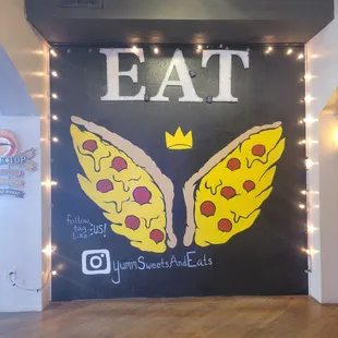 a wall with a sign that says eat