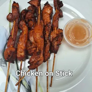 chicken skewers on a plate with dipping sauce