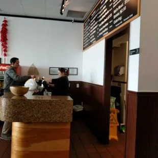 two people sitting at a counter in a restaurant