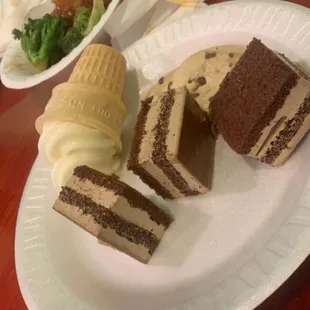 a slice of chocolate cake and ice cream on a paper plate