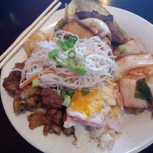 a plate of asian food with chopsticks