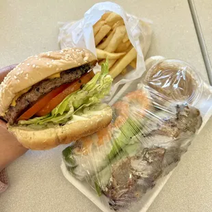 a person holding a hamburger and french fries