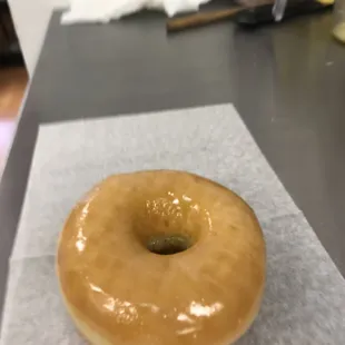 a glazed donut on a piece of wax paper