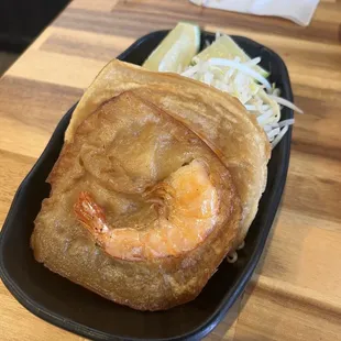 Close up of the fried shrimp cake, with steamed bean sprouts and lime