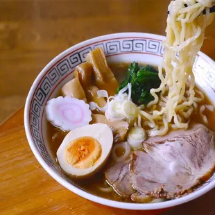 a bowl of ramen with meat and vegetables