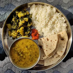 Our famous Yummy Plate with rice, veggie stir fry, lentil soup, and samosa