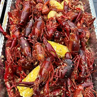 a tray full of crawfish, corn, and potatoes
