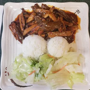 a plate of rice, meat and vegetables