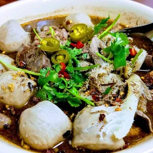 a bowl of food with chopsticks
