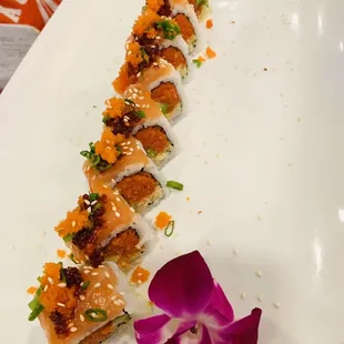 a plate of sushi with a flower