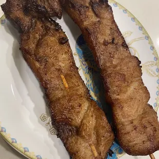 two meat skewers on a plate