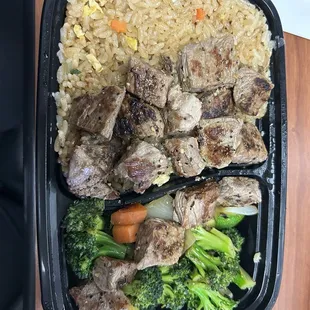 a meal of meat, rice, broccoli and carrots