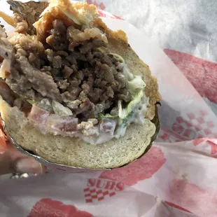 a hand holding a sandwich