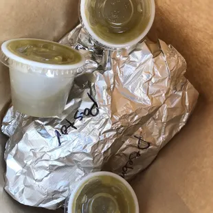 To-go tacos individually wrapped and labeled with free homemade medium and spicy sauces