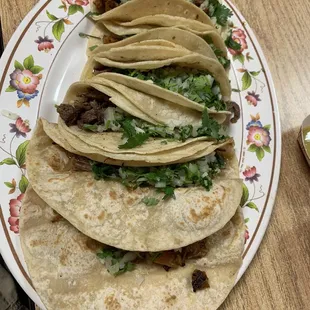 Tacos de harina y otros maíz y carnes, cebolla y cilantro