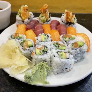 a plate of sushi with a bowl of dipping sauce