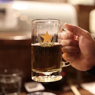 a person holding a glass of beer