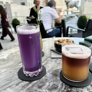 two drinks on a table with people in the background