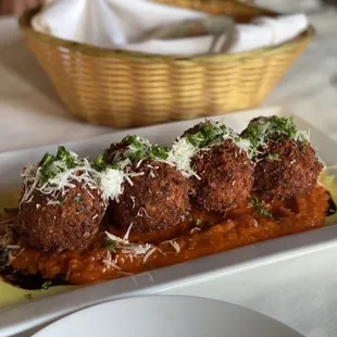 a plate of meatballs with sauce and parmesan cheese