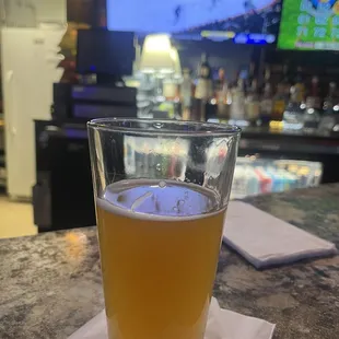 a glass of beer on a napkin