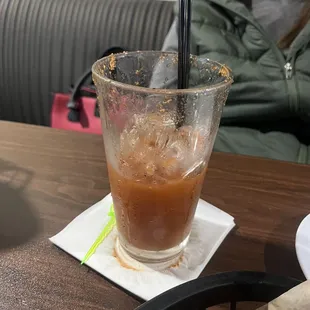a woman sitting at a table with a drink