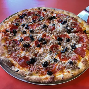 a pizza with pepperoni, olives, and cheese