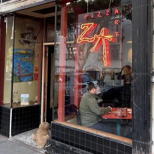 a man sitting at a table in front of a window