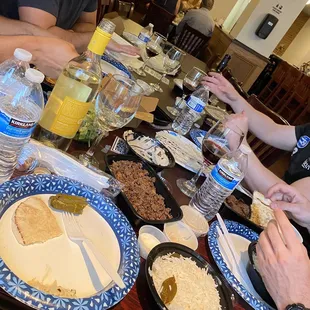 several people sitting at a table with plates of food