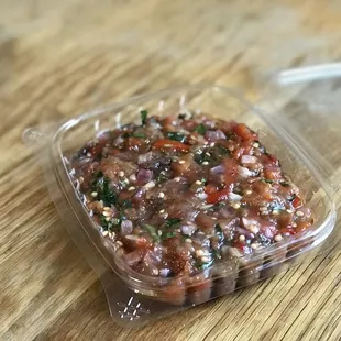 a plastic container with a sauce in it