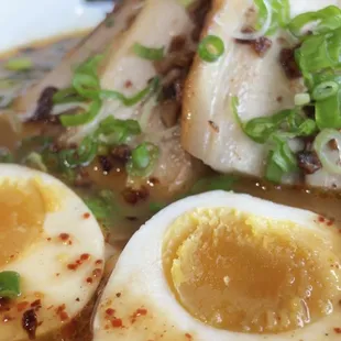 a close up view of a bowl of ramen with hard boiled eggs