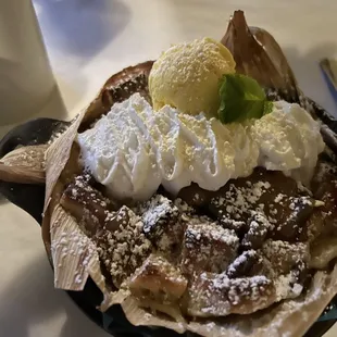 Bread pudding,ice cream and whipped cream in a tamale shell.