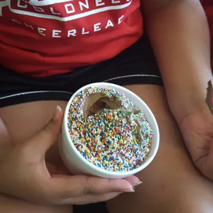a person holding a bowl of sprinkles