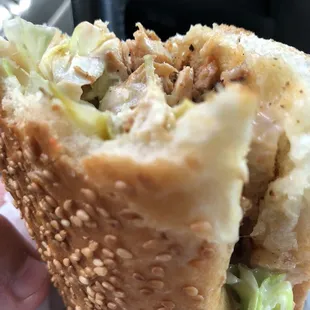 a hand holding a sandwich